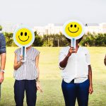 Westgate staff holding up smilie face signs over their faces