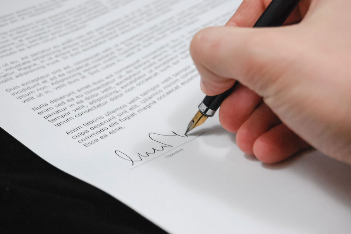 Photo of a hand signing a lease